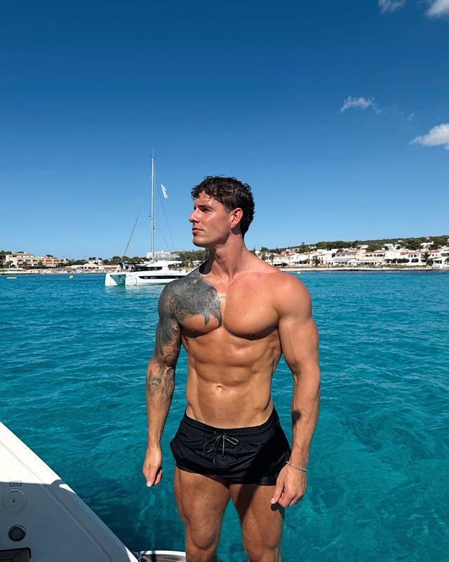 Luke on a boat over clear blue water (Instagram post)