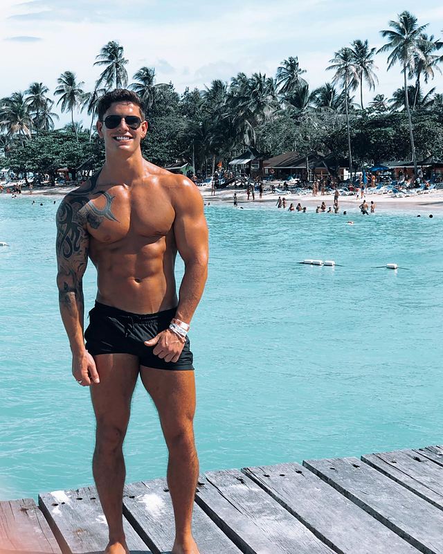 Luke on a wooden jetty over turquoise water (Instagram post)
